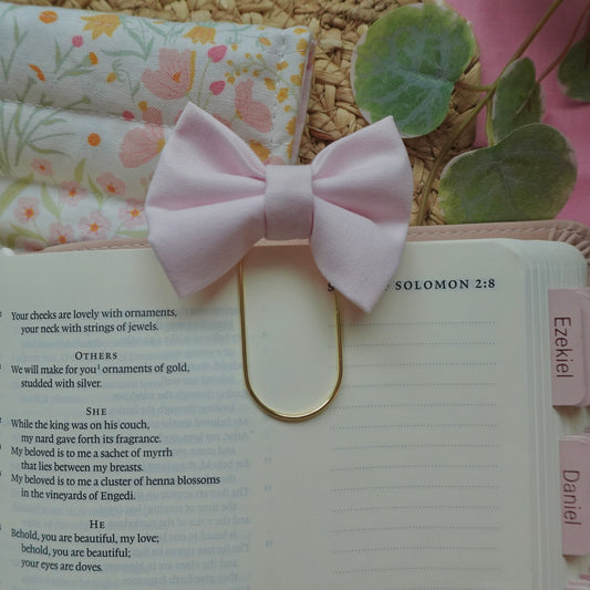 Pink bow bookmark on an open book with decorative elements